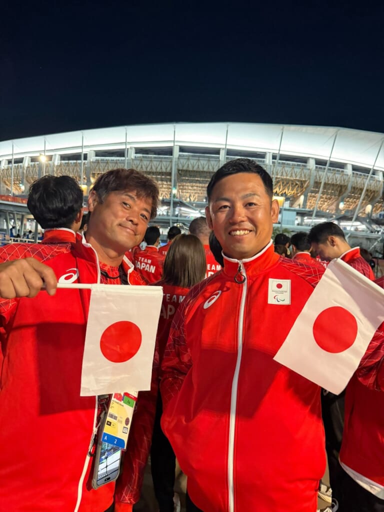 開会式で日本代表のウェアを着て日の丸を持つ選手たち